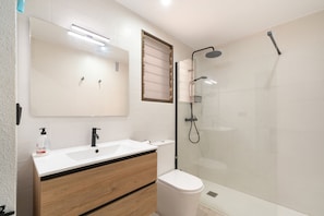 A modern bathroom with a double sink vanity, a toilet, and a glass-enclosed shower area. - Apartment 'Las Flores 1' with Wi-Fi and Air Conditioning (Murcia)