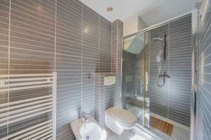 A modern bathroom with a shower, toilet, bidet, and a glass-enclosed shower area. - Charming apartment - 1BR - 2P - Saint-Tropez (Saint-Tropez)
