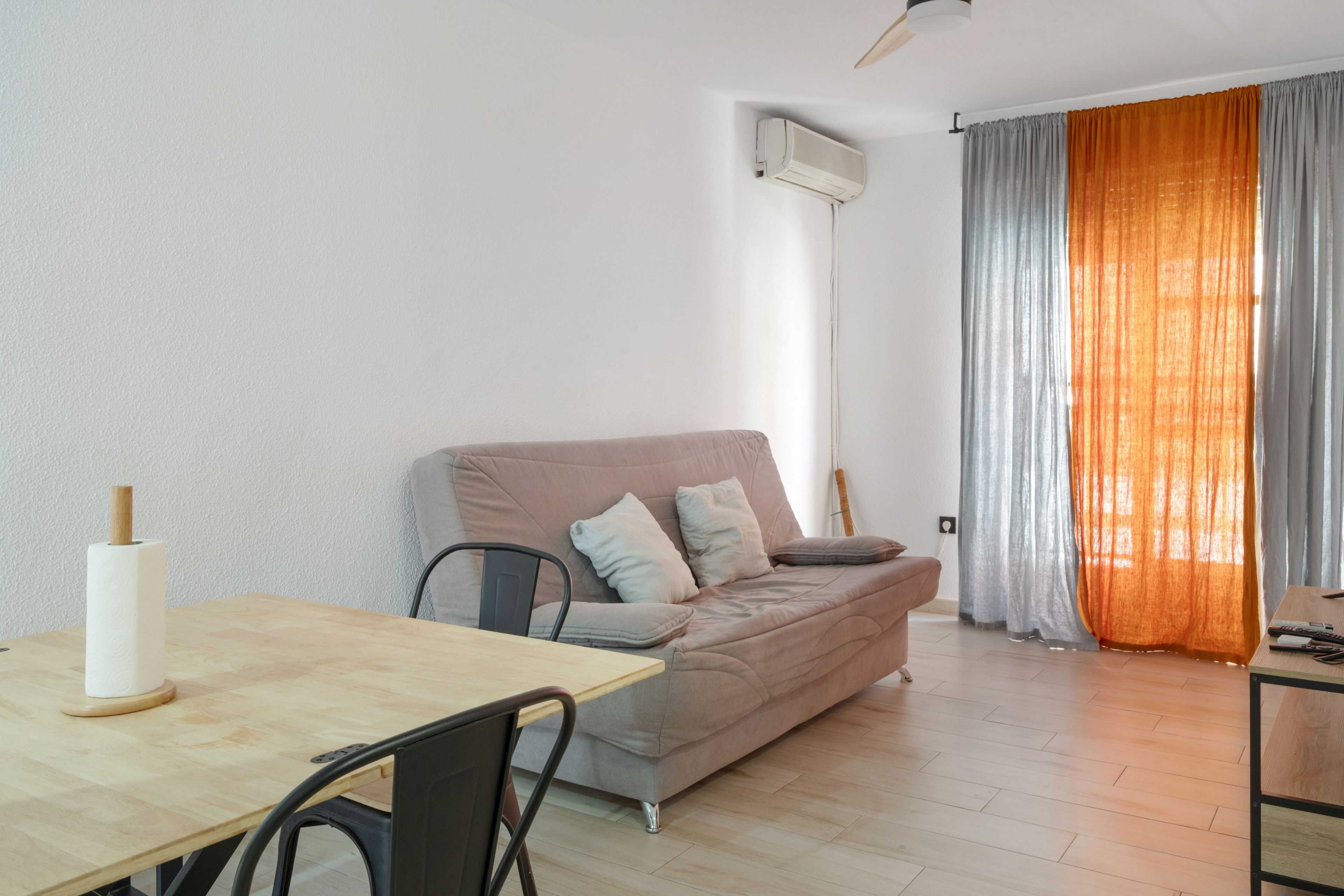 Una sala moderna con un sofá, una mesa de comedor y una silla.