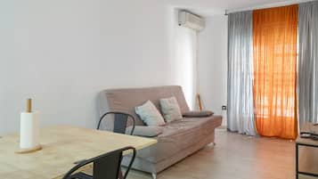 Una sala moderna con un sofá, una mesa de comedor y una silla.