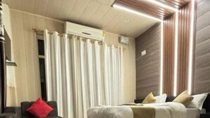 Un dormitorio moderno con cama, sofá y ventana con cortinas.