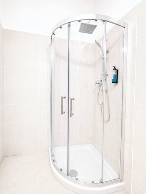 A glass-enclosed shower with a handheld showerhead, a wall-mounted faucet, and a soap dispenser. - Rialto Room on the Rialto Bridge (Venice)