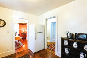 Eine Küche mit Kühlschrank, Toaster und Kaffeemaschine auf einem Regal.