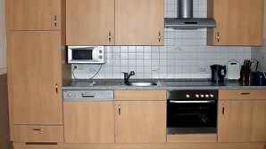 Keittiössä on puukehikoiset kaapit, mikroaaltouuni, liesi ja astianpesukone.