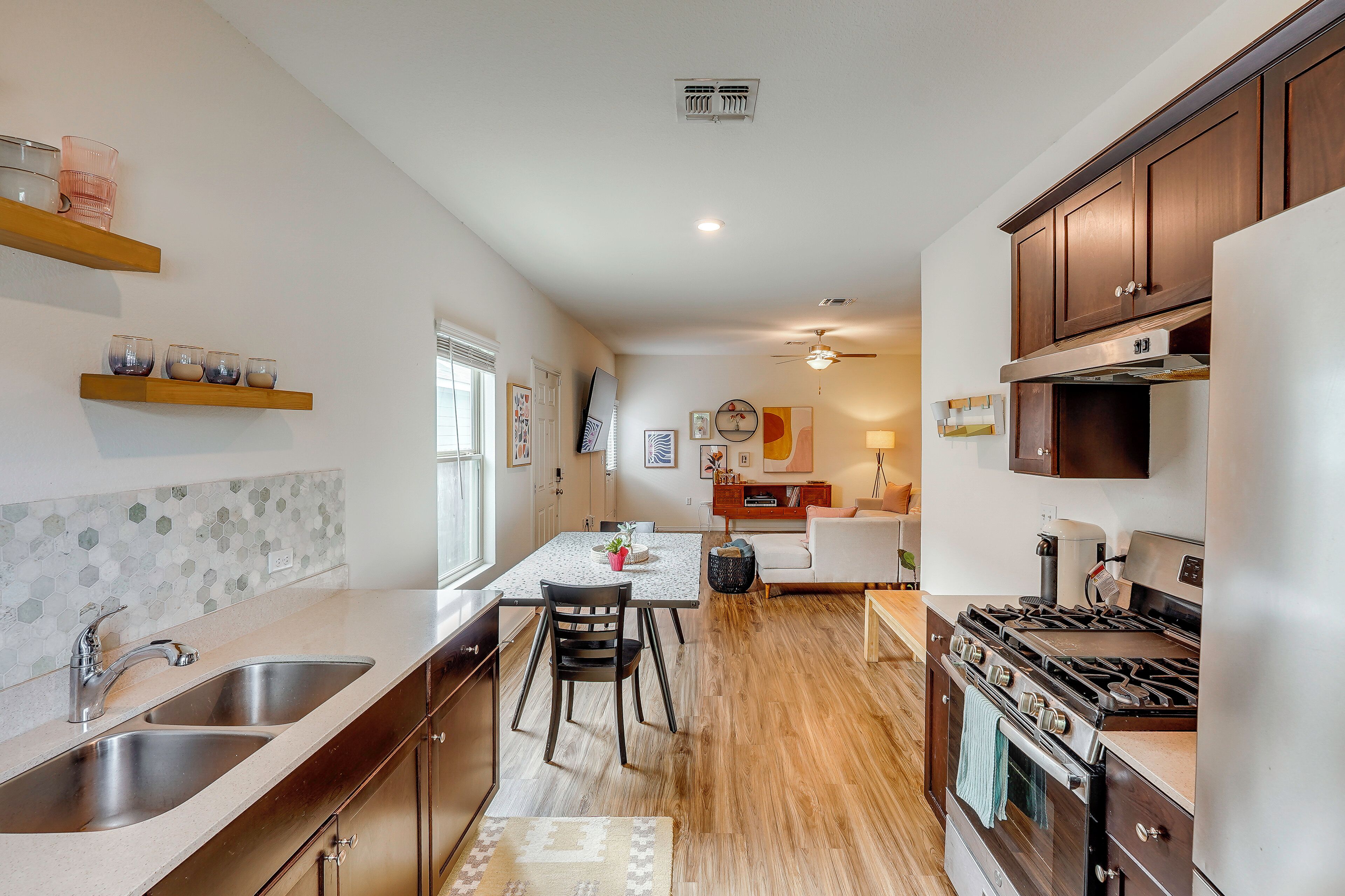 A modern kitchen with a central island, stainless steel appliances, and wooden cabinets.