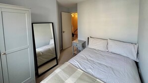 A bedroom with a bed, a bedside table, a mirror, and a wardrobe. - City Centre Home - Away from Home (Edinburgh)