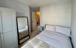 A bedroom with a bed, a bedside table, a mirror, and a wardrobe. - City Centre Home - Away from Home (Edinburgh)