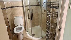 A bathroom with a glass-enclosed shower, a toilet, and a towel rack. - City Centre Home - Away from Home (Edinburgh)