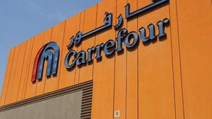 Un edificio con un cartel que dice 'Carrefour' en inglés y otro idioma.