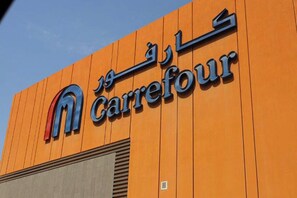 Ein Gebäude mit einem Schild, auf dem 'Carrefour' in Englisch und einer anderen Sprache steht.