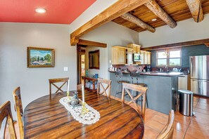 A dining area with a round wooden table, chairs, a white doily, and a candle. - Adobe-Style Taos Home with Great Views! (Taos)