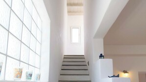 A staircase with a view of a window and a door at the top. - Picturesque home with amazing view (Paros)