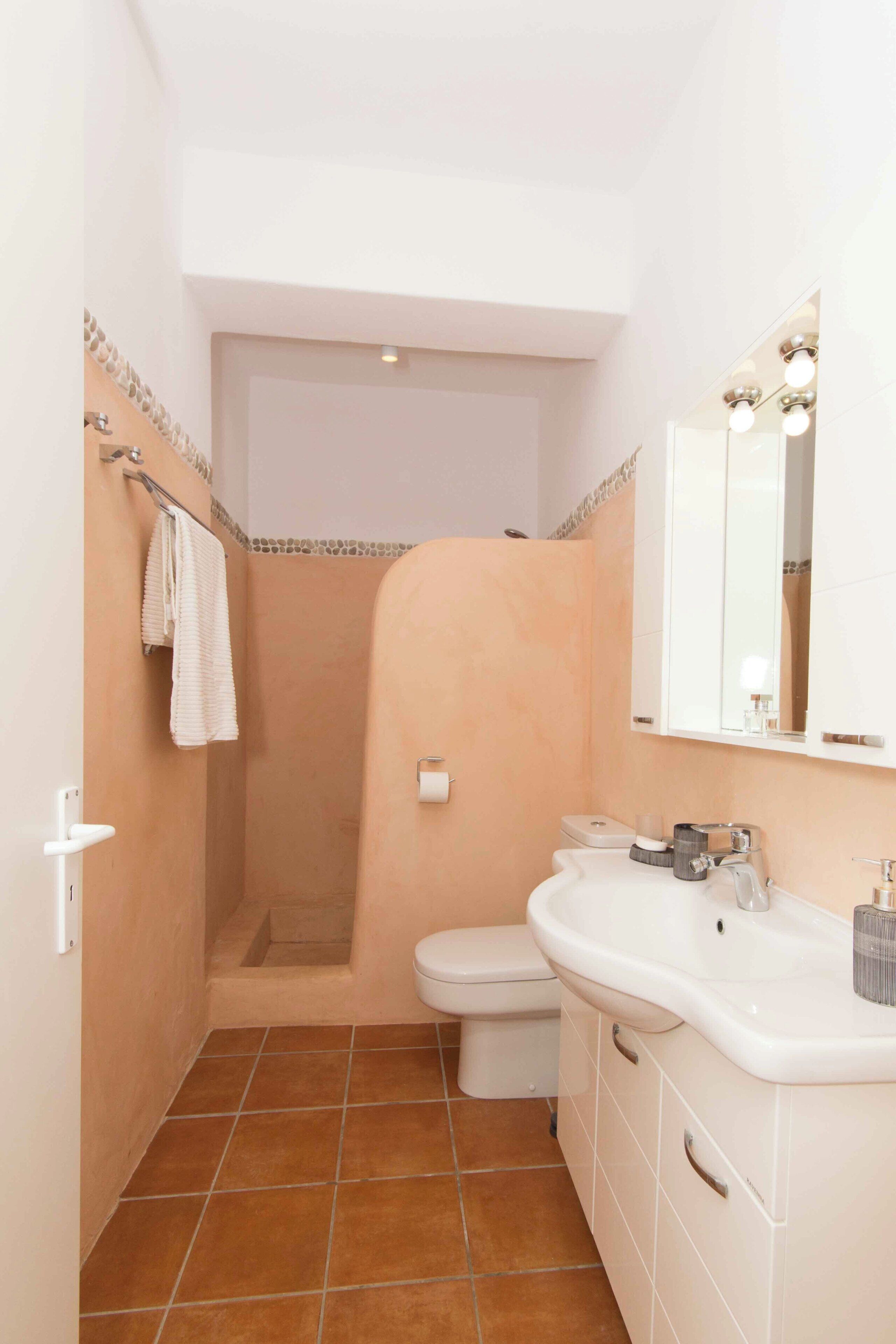 Ein Badezimmer mit Dusche, Toilette und Waschbecken.