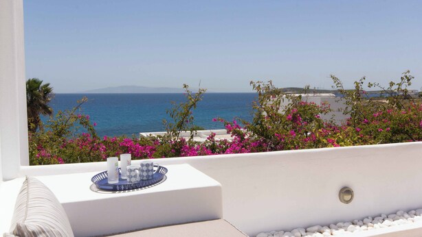 A balcony with a view of the sea, a white wall, and a tray with candles and a mug. - Picturesque home with amazing view (Paros)