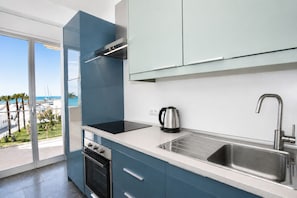 A modern kitchen with a built-in oven, a kettle, and a stainless steel sink. - La Casa di Luigi by Geco Vacation Rentals (Marina Di Ragusa)