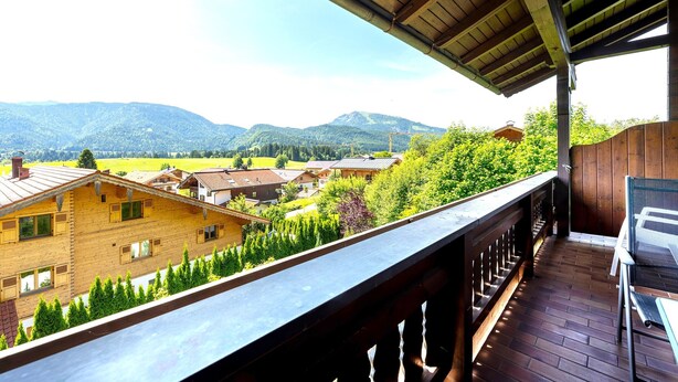 A balcony with a view of a mountain landscape, wooden buildings, and a clear sky. - "Schneehase" Vacation Rental with Terrace and Mountain View, 50 square meters (Reit im Winkl)