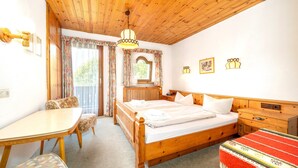 Um quarto de madeira com uma cama, uma mesa e uma cadeira.