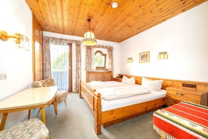 A wooden room with a bed, a table, and a chair. - Bergpieper Apartment: Apartment with a View and a Balcony (Reit im Winkl)