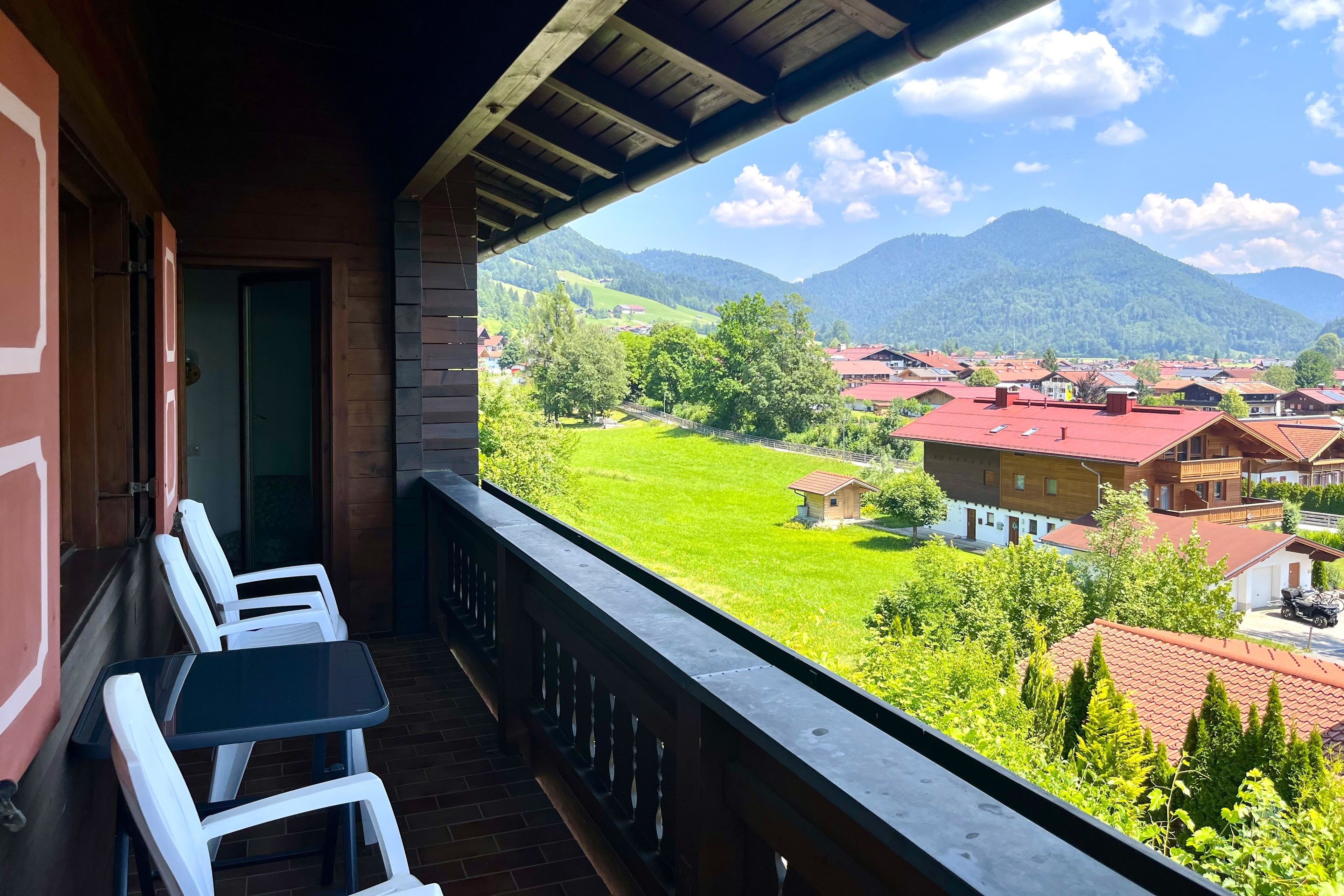 A balcony with a view of a village and mountains.