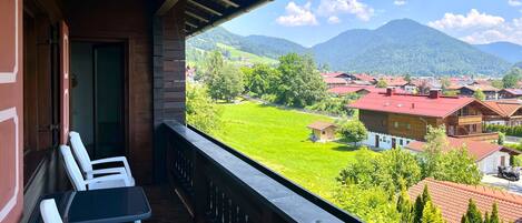 A balcony with a view of a village and mountains.