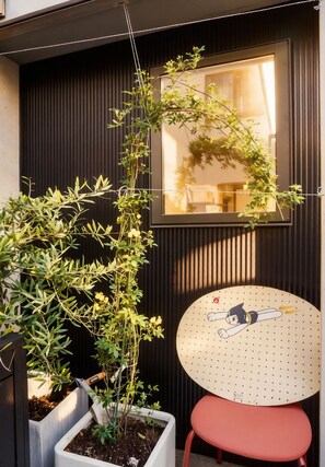 A potted plant, a chair, and a window with a view of the interior. - 2 train stops to Shinjuku | A Showa-era retro house (豊島区上池袋4丁目)