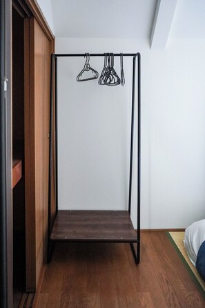 A room with a wooden wardrobe, a metal bed frame, and a hanging clothes rack. - 2 train stops to Shinjuku | A Showa-era retro house (豊島区上池袋4丁目)
