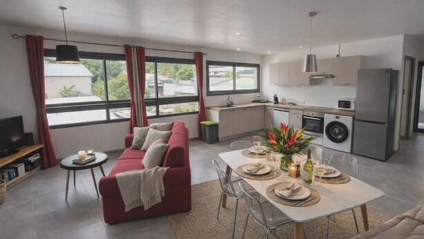 En moderne stue med sofa, spisebord og et køkkenområde.