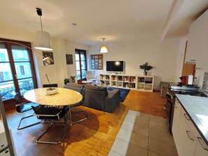 A modern living room with a round table, sofas, a TV, and a bookshelf. - Eaux-Vives - Near the tram, the lake, and the Jet d'Eau (Genève)