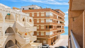 Un hotel de varios pisos con balcones, vistas a la playa y una zona junto a la piscina.