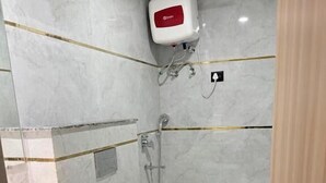 Un baño moderno con un lavamanos blanco, una bañera blanca y un cabezal de ducha.
