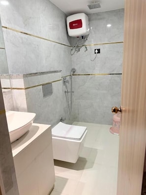 Um banheiro moderno com uma pia branca, uma banheira branca e um chuveiro.