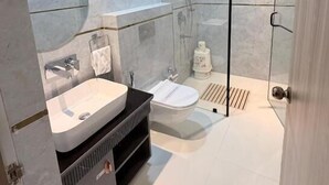 Un baño moderno con cabina de ducha de vidrio, lavamanos y retrete.