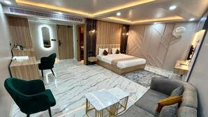 Quarto moderno com cama, sofá, escrivaninha e cadeira.