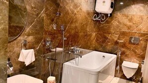 Uma casa de banho moderna com uma banheira grande, área de duche separada, toucador com lavatório e sanita.