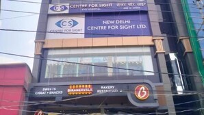 Un edificio de varios pisos con letreros que indican 'Centre for Sight' y 'Bikanerwala' en la planta baja.