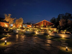A modern house with a stone pathway and garden lighting.