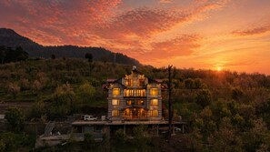 A multi-story house with a balcony, surrounded by trees and hills. - AKIRA BY SKYLORE (Manali)