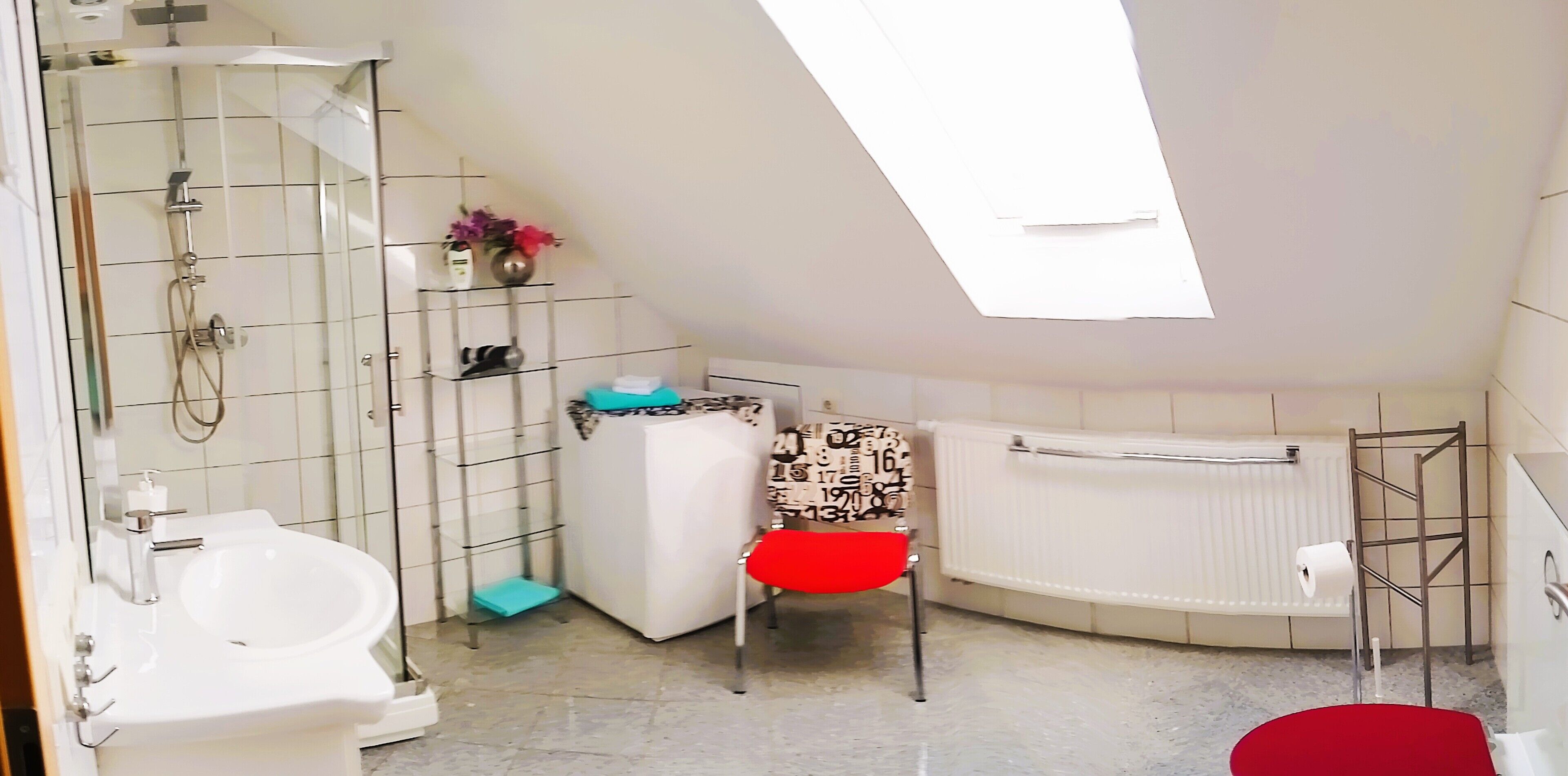 Un baño con ducha, inodoro, bidé y radiador.