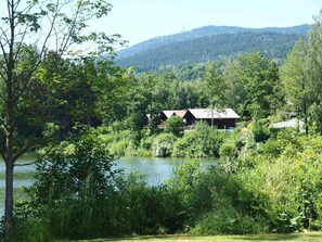 Ein Seeufer-Lodge mit rustikalen Blockhütten, umgeben von dichtem Wald und Hügeln.