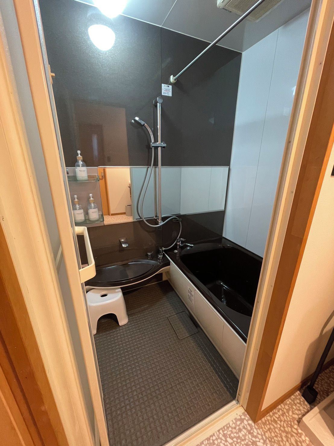 A compact bathroom with a bathtub, a toilet, and a shower.