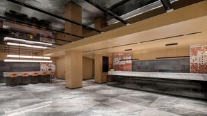 Un interior moderno con zona de bar, asientos y pared con diseño.