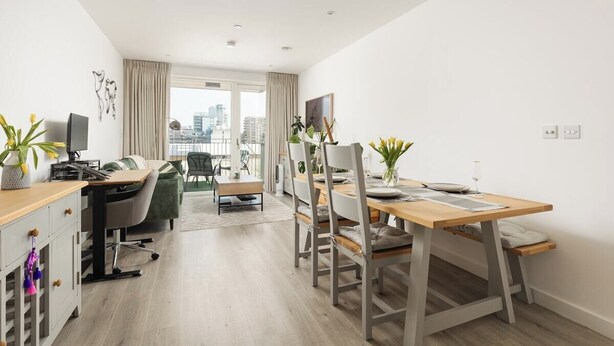 Een modern appartement met een eethoek, werkruimte en uitzicht over de stad.