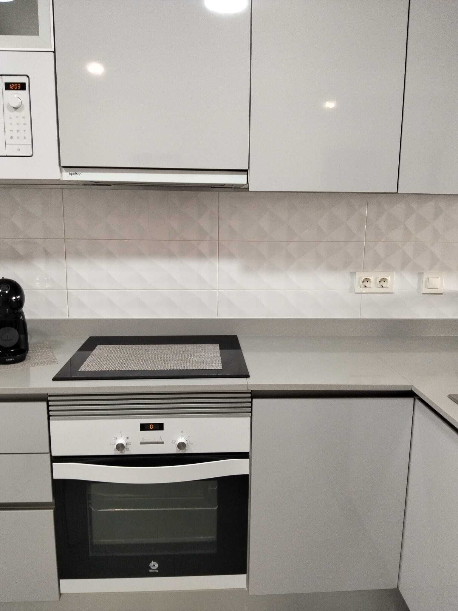 Eine Küche mit Mikrowelle, Backofen und Kaffeemaschine.
