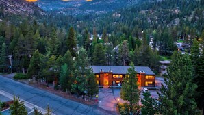 A modern two-story building with a flat roof, surrounded by dense forest and mountains. - Walk to Lifts + Tram and KT-22 Views | Olympic Valley | Tram Condo (Olympic Valley)