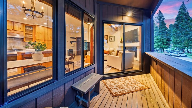A modern interior with a kitchen, dining area, and living room, connected by large sliding glass doors. - Walk to Lifts + Tram and KT-22 Views | Olympic Valley | Tram Condo (Olympic Valley)