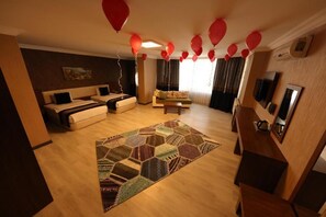 A hotel room with a sofa set, a patterned rug, and a television. - Royal Berk Hotel (Van)