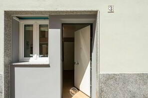 A doorway leading to a room with a sliding glass door and a small window. - Repubblica Apartment | City Stay & Fast WiFi (Cagliari)