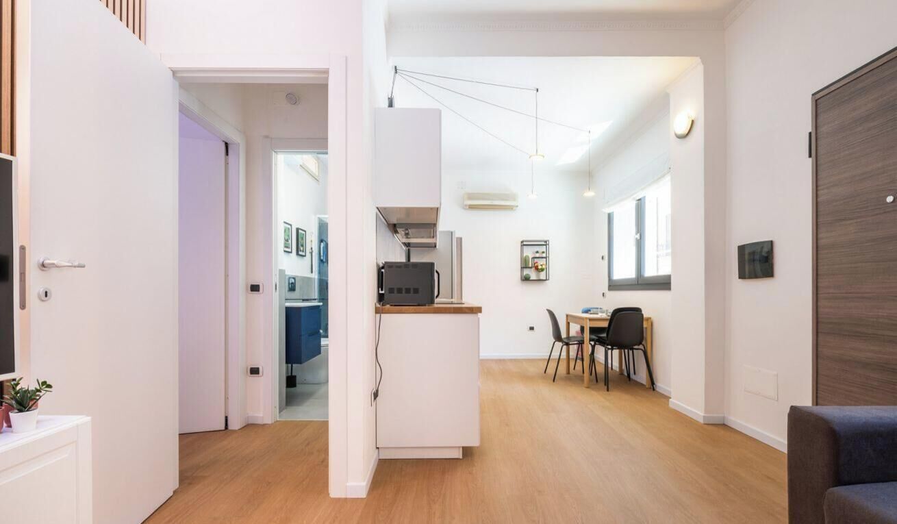 A modern interior with a kitchen area, dining space, and a seating area.