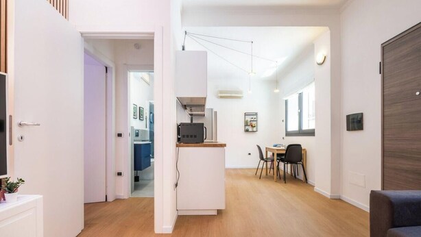 Ein modernes Interieur mit Küchenbereich, Essbereich und einer Sitzecke.