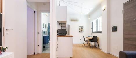 A modern interior with a kitchen area, dining space, and a seating area.